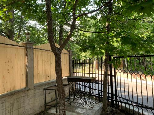a picnic table under a tree next to a fence at Eco Chalet Tsaghkadzor in Tsaghkadzor