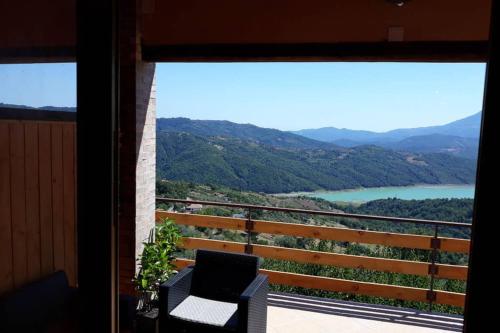 a room with a balcony with a view of a lake at PANORAMIKA in Cicerale