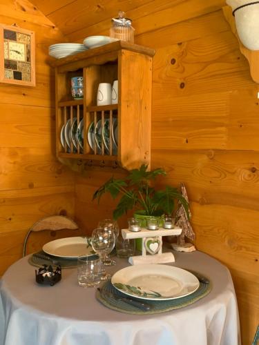 a table with plates and glasses on it in a cabin at La Roulotte du Randonneur in Rimbach-près-Masevaux