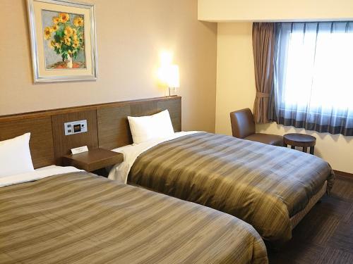 伊賀市的住宿－Route Inn Grantia Wakuranoyado Igauenojomae，酒店客房,配有两张床和椅子