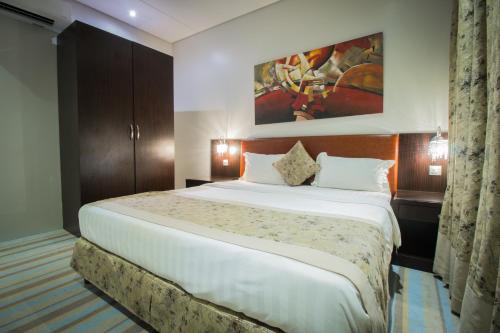 um quarto com uma cama grande num quarto em Amar Furnished Hotel Apartments em Riyadh
