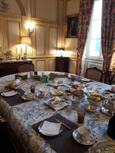 - une table à manger avec de la nourriture dans l'établissement Chambres d'Hôtes de Manoir de Captot, à Canteleu