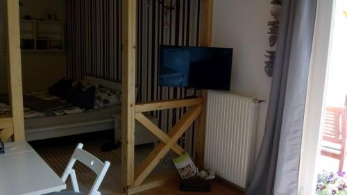 a television on a stand in a room with a crib at Appartement Schönberger in Rodder