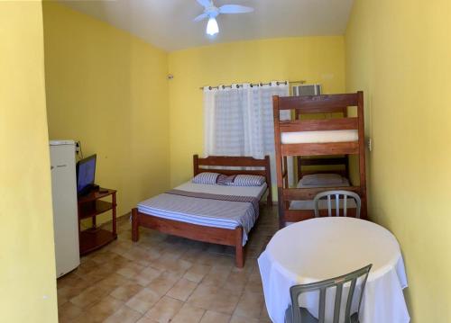 Cette chambre comprend 2 lits superposés et une table. dans l'établissement Pousada Bertimar, à Bertioga