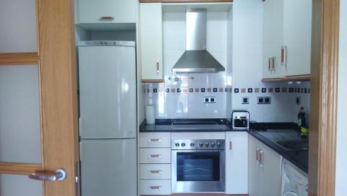a kitchen with a refrigerator and a stove top oven at Apartamento playa Cambrils edificio Torresol in Cambrils