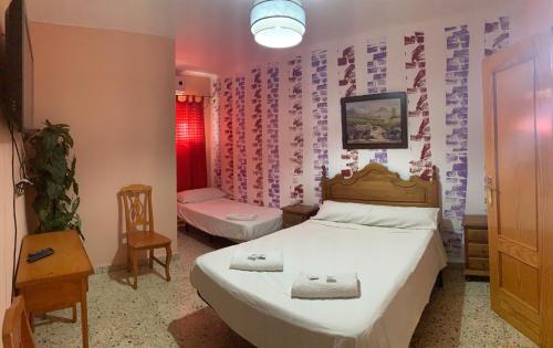a bedroom with a bed and a table and a chair at Hostal Seseña in Seseña