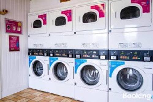 four washers and dryers in a laundry room at Premium Chalet at Newquay Away Resorts MV7 in Newquay