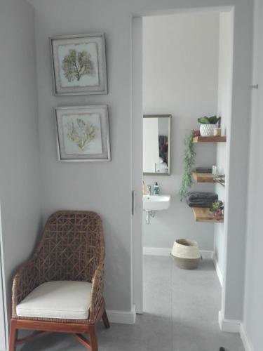 a bathroom with a chair and a sink at EGRETS` ĂRK in Gansbaai