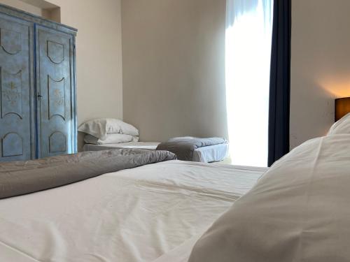 a bedroom with two white beds and a window at Jazz Hotel in Naples