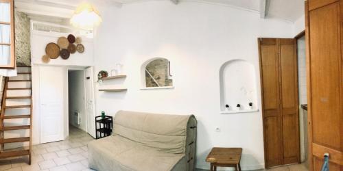 a living room with a chair and a table at Mazet indépendant Tavel - Le Mas de l Acacia in Tavel