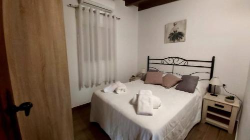 sypialnia z łóżkiem z białymi prześcieradłami i poduszkami w obiekcie Casa Rural La Resbala - Casa Tajinaste w mieście La Orotava