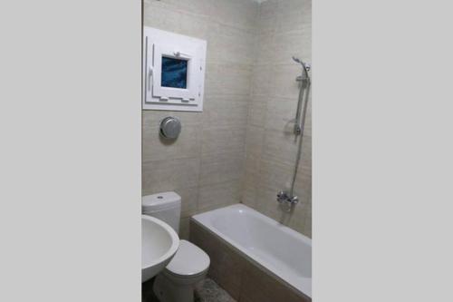 a bathroom with a tub and a toilet and a sink at Sunny modern apartment with good internet, near from city center of Alexandria in Alexandria