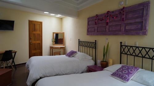 a hotel room with two beds and a mirror at J&K Suite in San Cristóbal de Las Casas