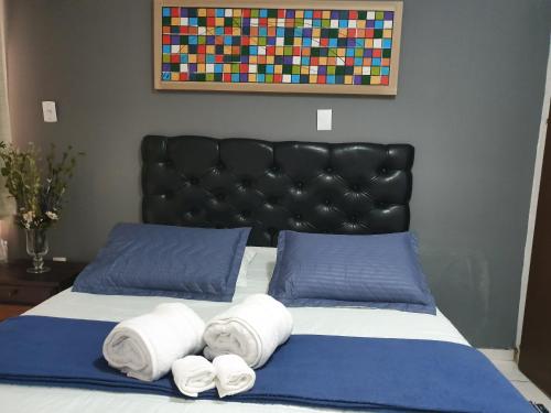 a bedroom with a bed with two towels on it at Pousada Solar dos Cavaleiros Mendes in Macaé