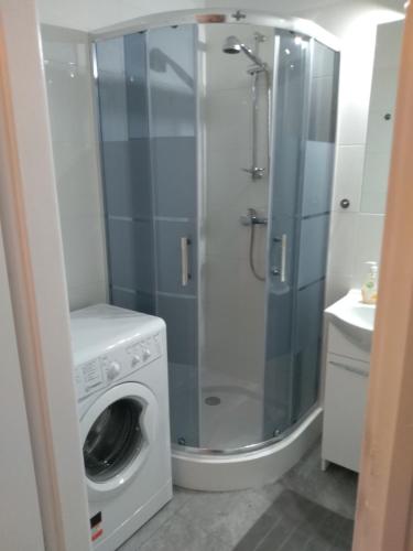 a bathroom with a washing machine and a washer at Apartament Centrum in Radom