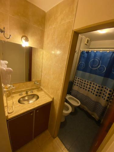 a bathroom with a sink and a toilet and a mirror at Junin Centro Apartament in San Miguel de Tucumán