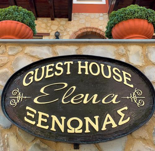 a sign for a guest house in front of a building at Elena Guesthouse in Kalabaka