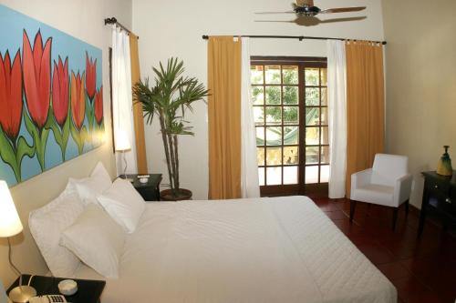 a bedroom with a white bed and a window at Pousada dos Girassóis in Pipa