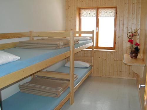 Zimmer mit 2 Etagenbetten und einem Fenster in der Unterkunft Rifugio Fronza alle Coronelle - Kölner Hütte in Welschnofen
