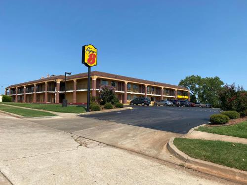 a building with a traffic light next to a street at Super 8 by Wyndham Midwest City OK in Midwest City