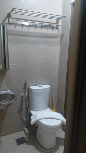a bathroom with a toilet and a sink at Blue Eyes Hotel in Kepala Batas