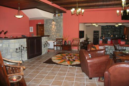 una sala de estar con paredes rojas y muebles de cuero. en Archontiko Velousi, en Athamanía