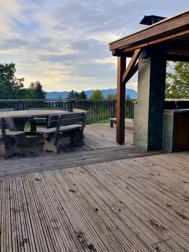 a wooden deck with a picnic table and a pavilion at Gozdarjeva koča nad Rimskimi Toplicami in Dol pri Hrastniku
