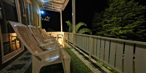 two chairs sitting on a balcony at night at บ้านเอื้อมดาว เขาค้อ in Ban Huai Phai