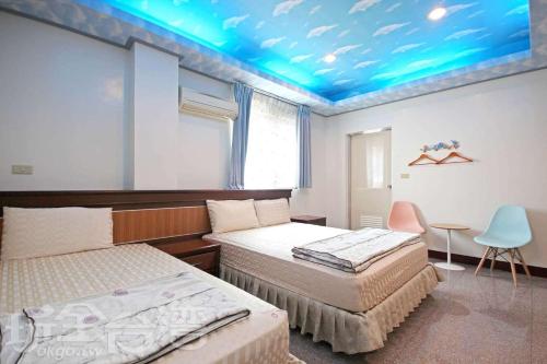 Jiji的住宿－集集蘋果的家民宿，一间卧室设有两张床和蓝色的天花板