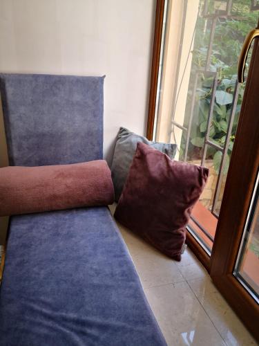 a couch with two pillows sitting next to a window at Затишні апартаменти, Дерибасівська in Odesa