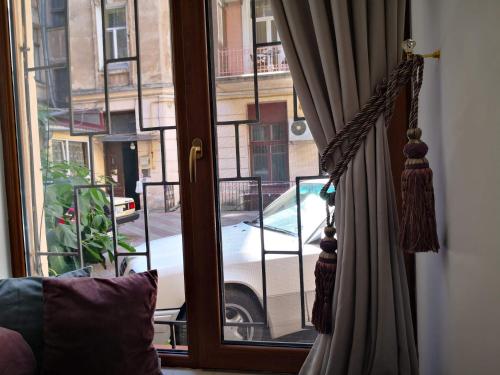 a window with a view of a car parked on a street at Затишні апартаменти, Дерибасівська in Odesa