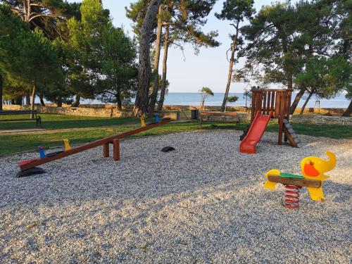 um parque com parque infantil com escorrega e brinquedos em MIRTA deluxe SUPERIOR 5 star apartment, your piece of heaven by the sea & park, with sea & park view em Novigrad Istria