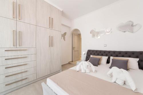 a white bedroom with two elephants on a bed at Panos Villa Sunset View in Parikia