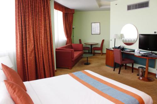 a hotel room with a bed and a desk at Al Diar Dana Hotel in Abu Dhabi