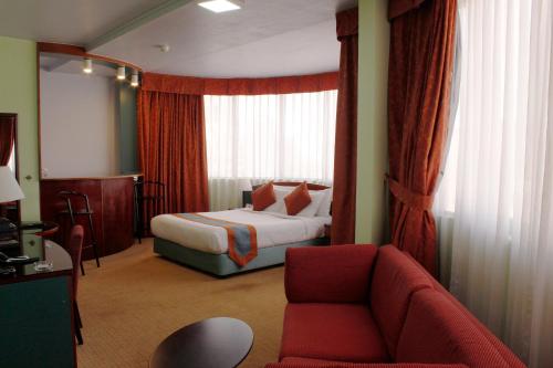 Habitación de hotel con cama y sofá en Al Diar Dana Hotel, en Abu Dabi