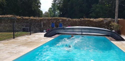 a person is in a swimming pool at La Bergerie in Suèvres
