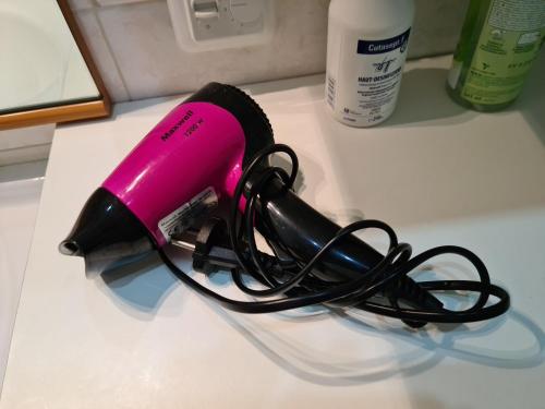 a pink and black hair dryer sitting on a counter at Mustvee Creek Cottage in Mustvee