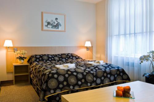 une chambre d'hôtel avec un lit et une table dans l'établissement Art Hotell, à Rakvere