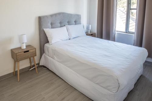 Un dormitorio con una gran cama blanca y una ventana en Lotus Stay Manly - Apartment 29G en Sídney