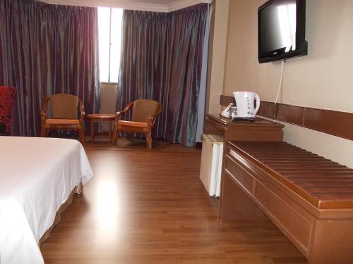 a hotel room with a bed and a flat screen tv at Hotel Grand Crystal in Alor Setar