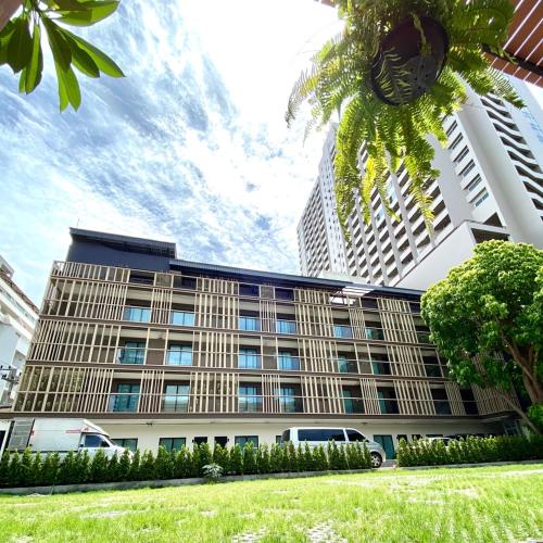 a building with a palm tree in front of it at The Shade Residence in Pattaya