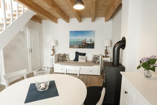 ein weißes Wohnzimmer mit einem Tisch und einem Bett in der Unterkunft Hotel & Ferienunterkünfte Hus Seeblick in Fehmarn