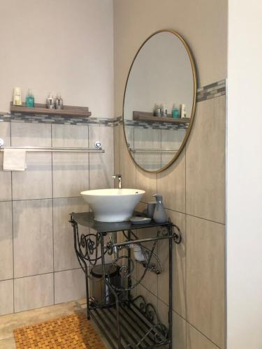 a bathroom with a sink and a mirror at Ruebys Apartment 202 in Dullstroom