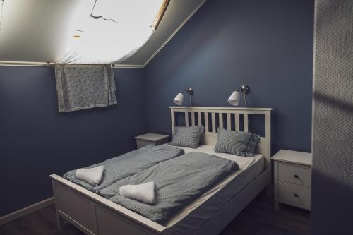 1 dormitorio azul con 1 cama con 2 almohadas en Kerámia - Vendégszobák en Szekszárd