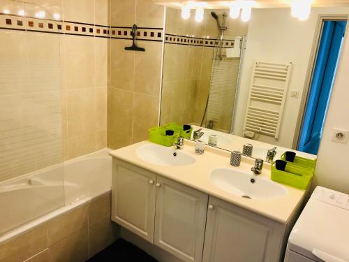 a bathroom with a sink and a mirror and a tub at La Cancalaise - Bel appartement T4 tout confort - proche de la plage - Cancale in Cancale