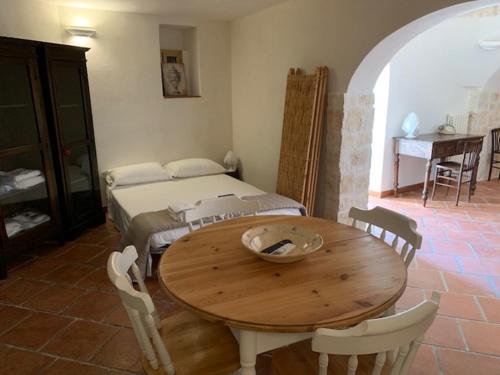 een tafel en stoelen in een kamer met een bed bij Trulli Santa Maria Odegitria Relais in Ostuni