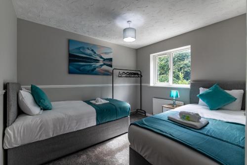 a bedroom with two beds and a window at Chandlers House in Peterborough