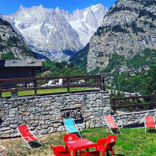 a group of chairs and tables on top of a mountain at Hotel Ottoz Meublé in Courmayeur
