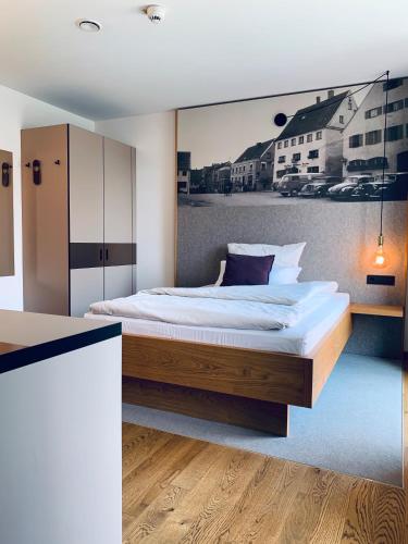 a bedroom with a bed with a picture on the wall at Stadthotel Kachelofen in Krumbach
