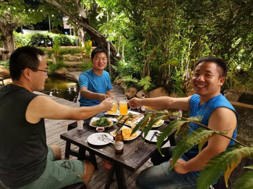 a group of men sitting around a table eating food at Interpark Hotel & Residence, Eastern Seaboard Rayong in Ban Phan Sadet Nok